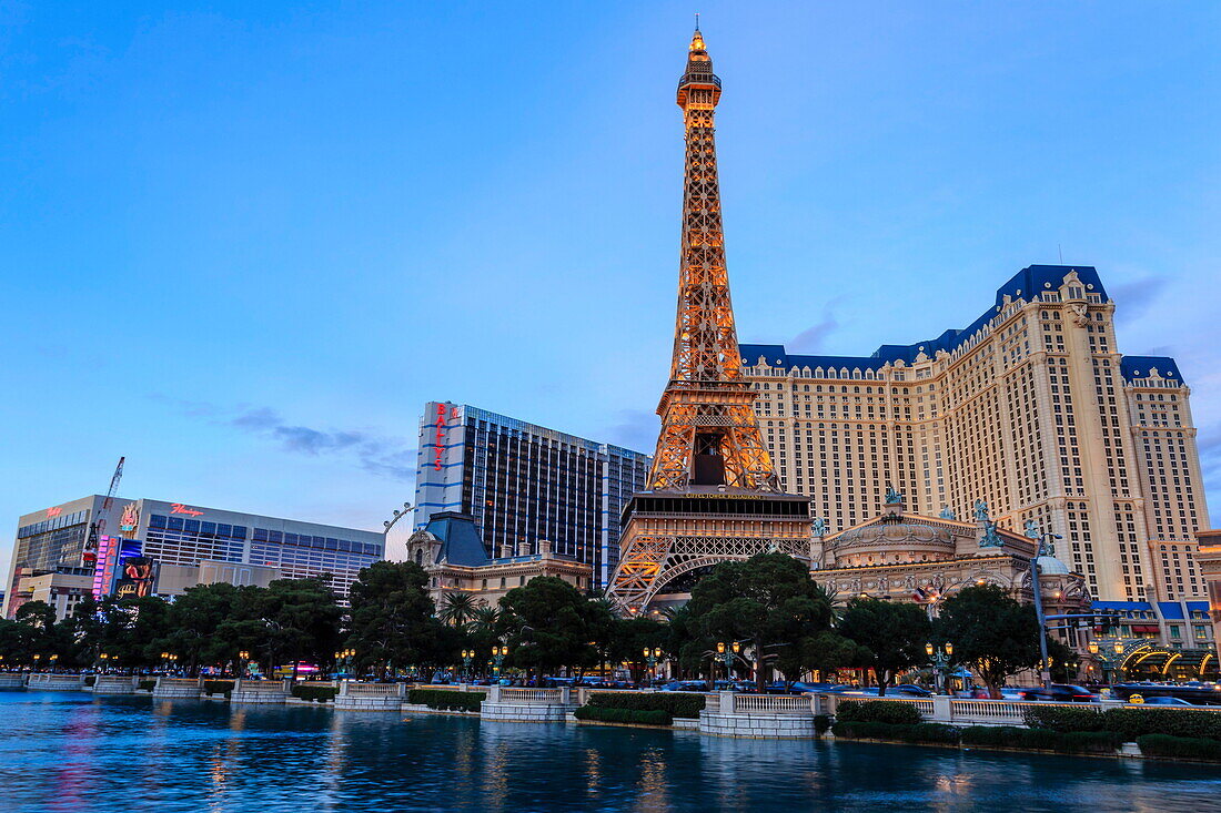 Paris, Ballys and Flamingo Hotels and High Roller Observation Wheel at dusk, viewed across Bellagio Lake, Las Vegas, Nevada, United States of America, North America