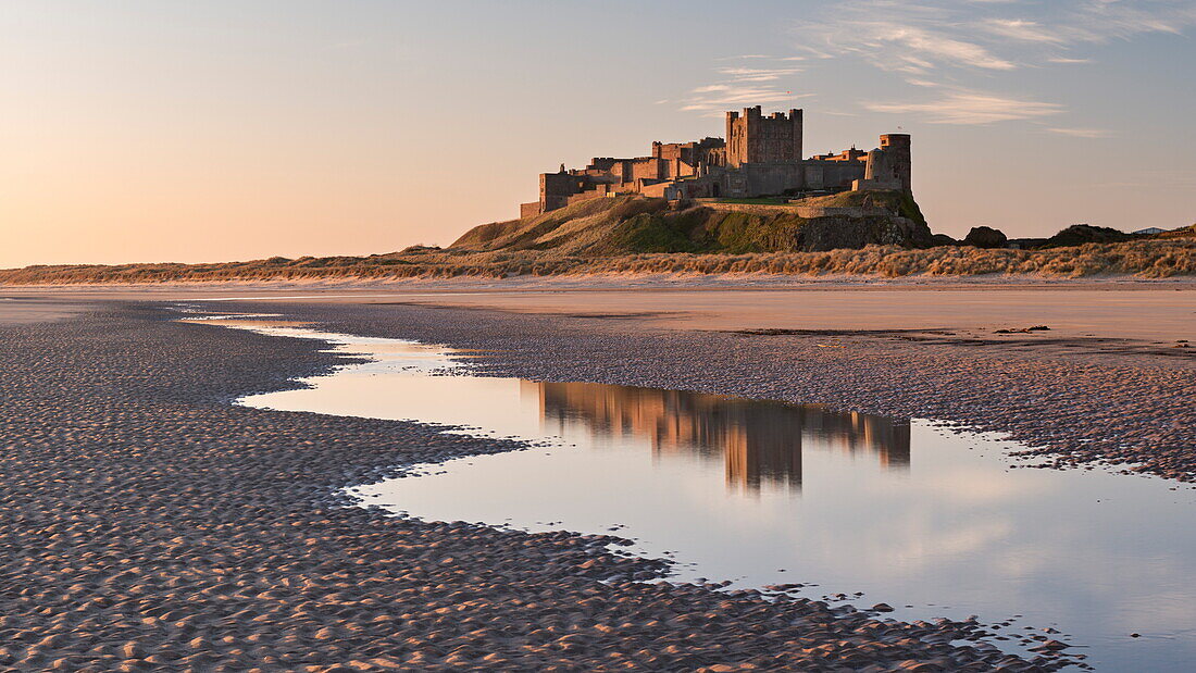 Bamburgh Castle and reflection in Bamburgh Beach tidal pools, Northumberland, England, United Kingdom, Europe