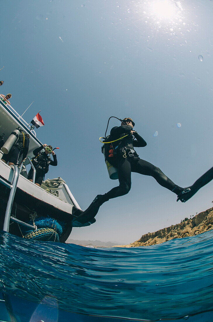 Scuba diver making giant stride entry into the water, Red Sea, Egypt, North Africa, Africa