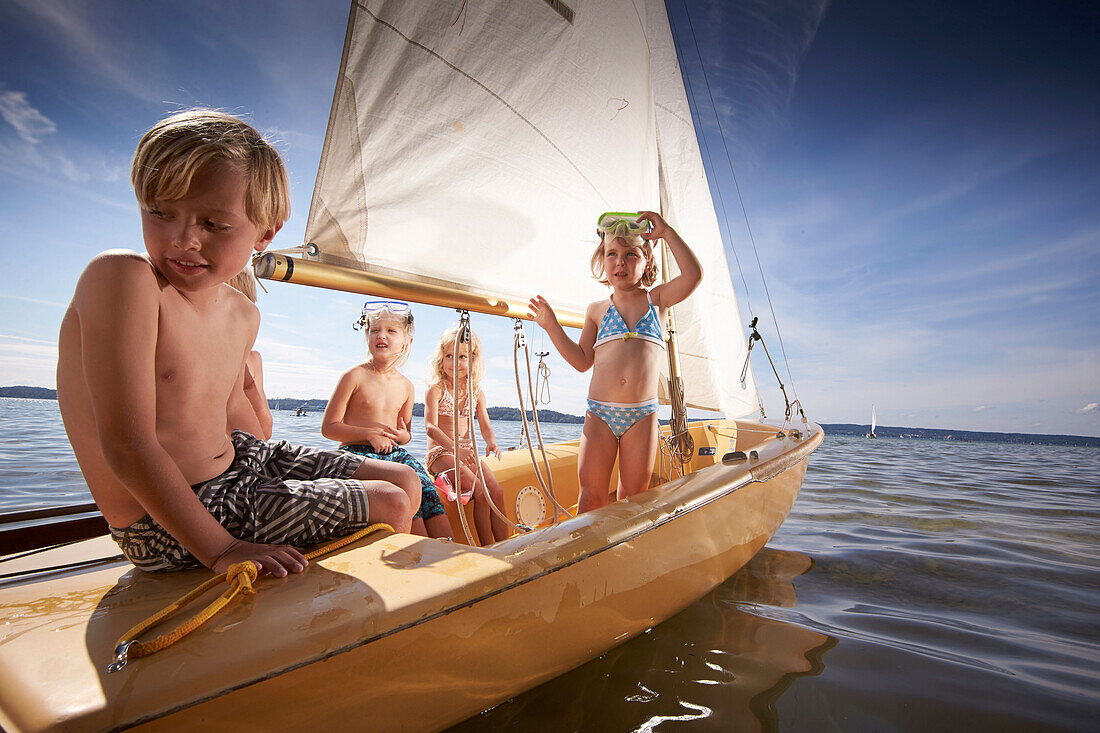 Children in a sailing boat on lake Starnberg, Upper Bavaria, Bavaria, Germany