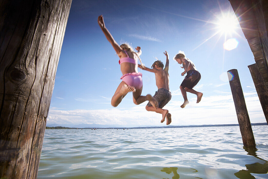 Children jumping into lake Starnberg, Upper Bavaria, Bavaria, Germany