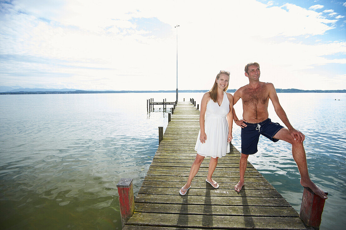 Couple on a jetty at lake Starnberg, Upper Bavaria, Bavaria, Germany