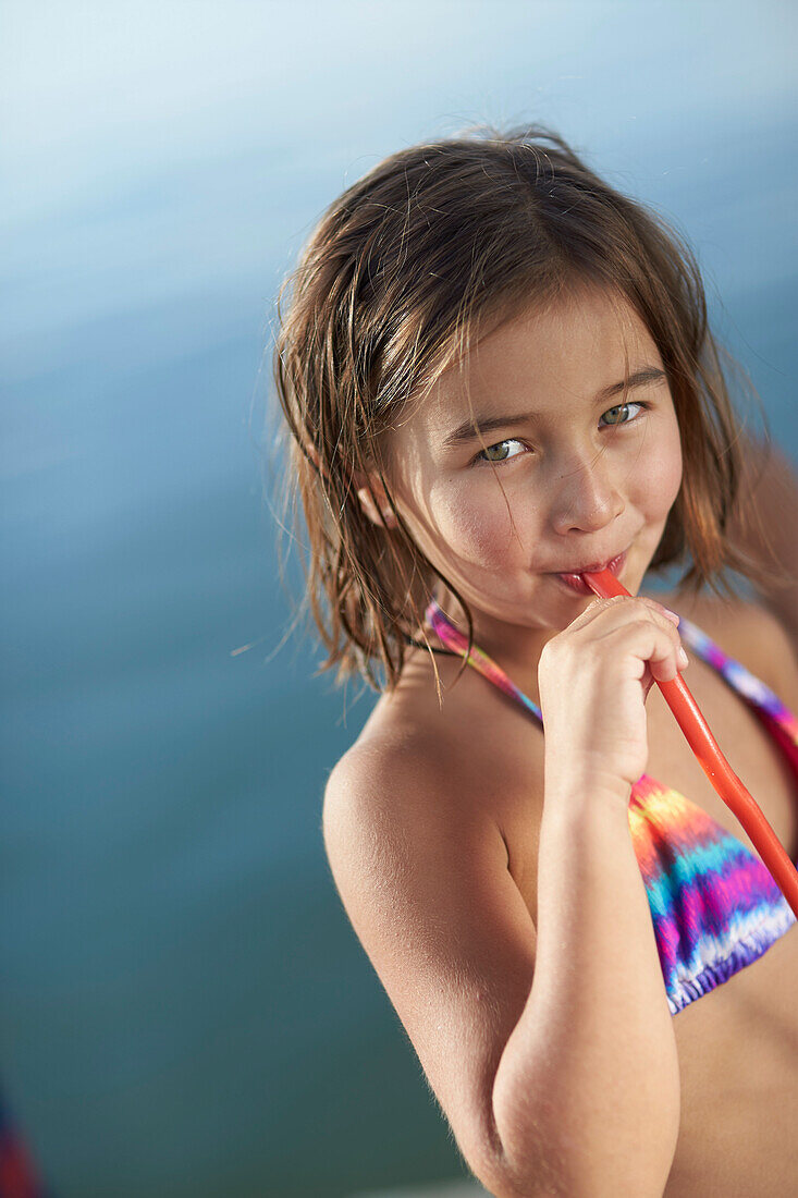 Girl with a fruitgum stick, lake Starnberg, Upper Bavaria, Bavaria, Germany