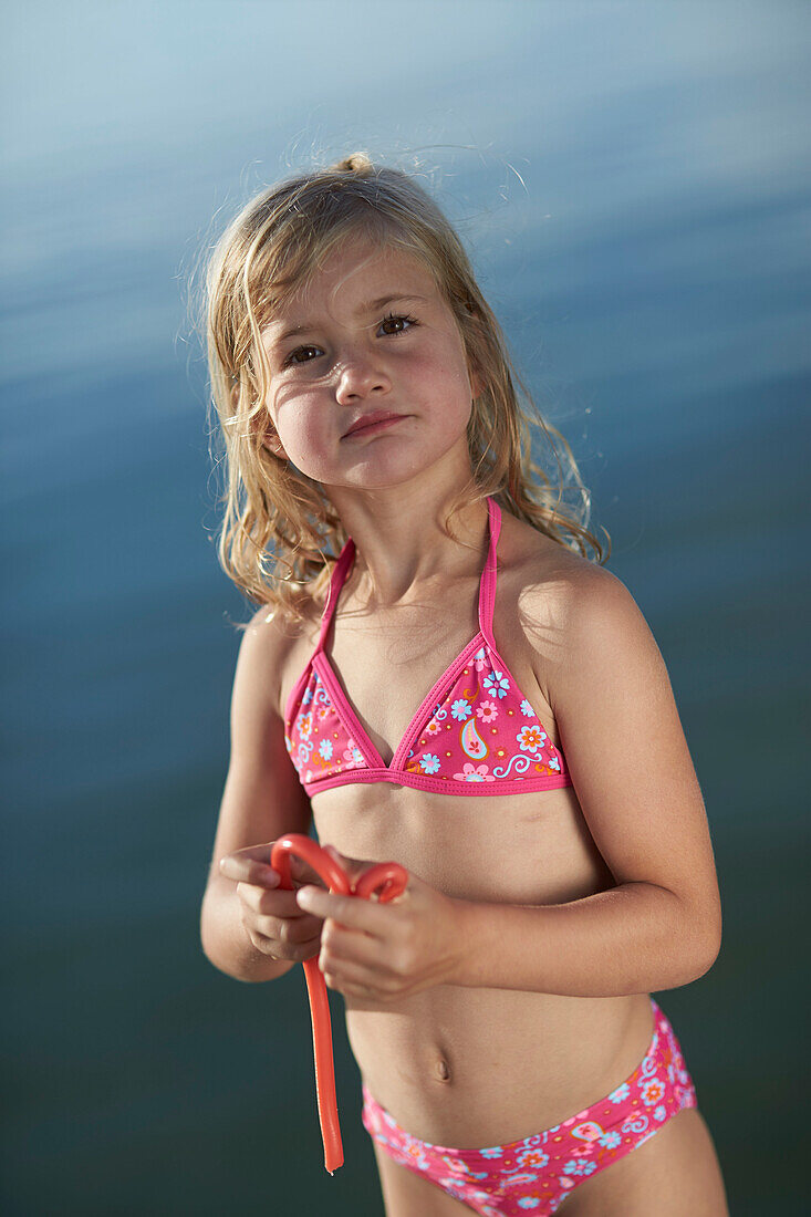 Girl with a fruitgum stick, lake Starnberg, Upper Bavaria, Bavaria, Germany