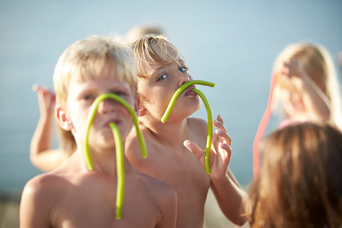 Two boys with fruitgum sticks, lake Starnberg, Upper Bavaria, Bavaria, Germany