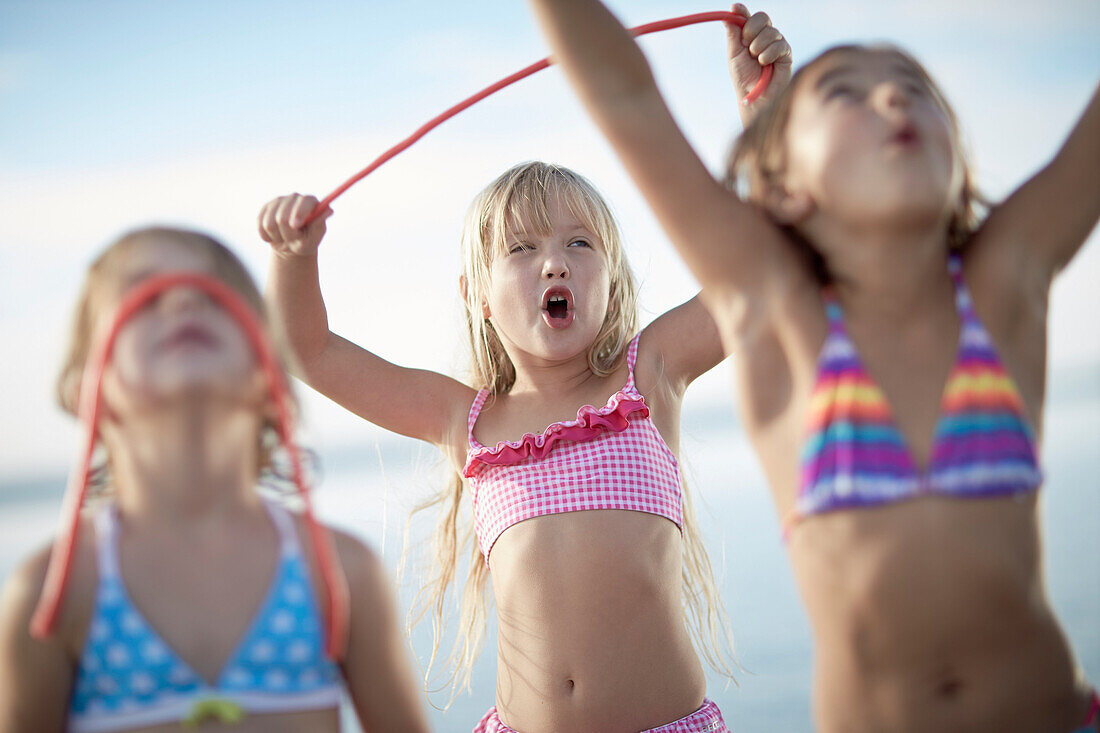 Three girls with fruitgum sticks, lake Starnberg, Upper Bavaria, Bavaria, Germany