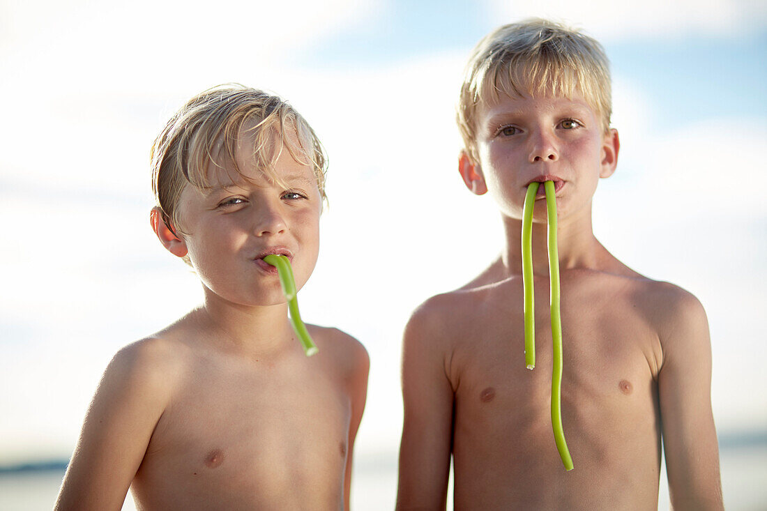 Zwei Jungen essen Fruchtgummistangen, Starnberger See, Oberbayern, Bayern, Deutschland