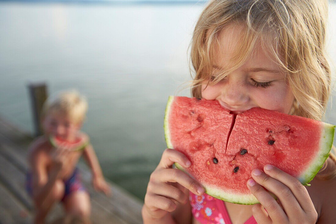 Girl eating a slice of melon, lake Starnberg, Upper Bavaria, Bavaria, Germany