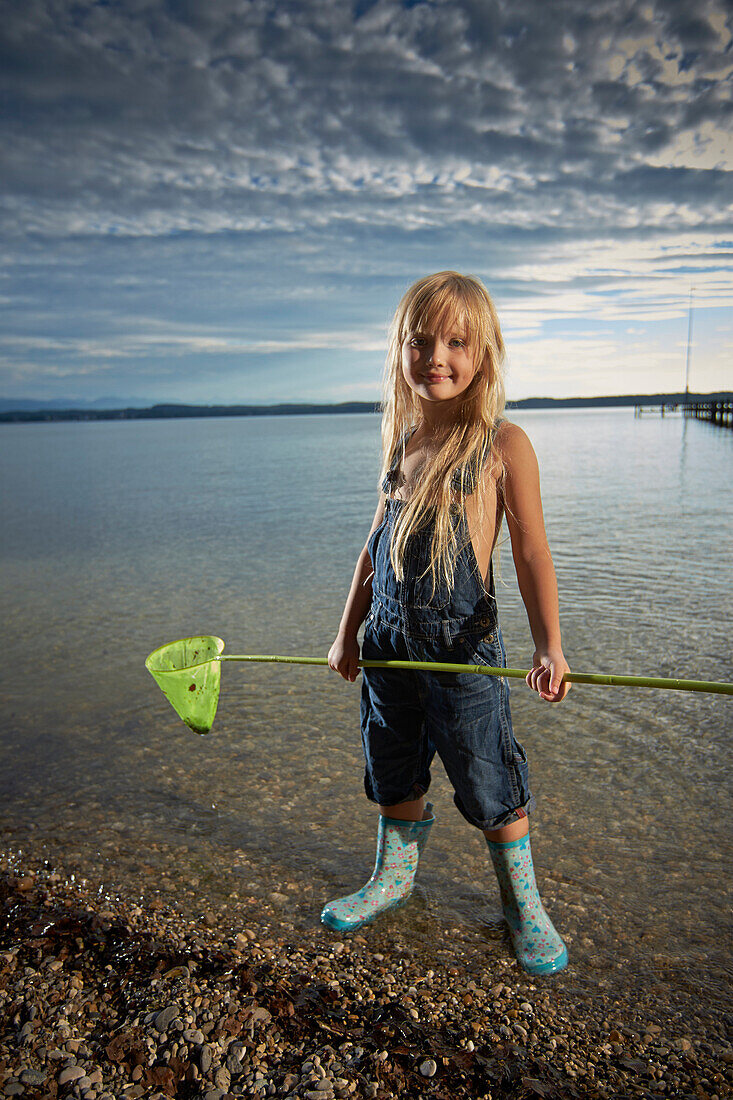 Girl with a dip net in lake Starnberg, Upper Bavaria, Bavaria, Germany