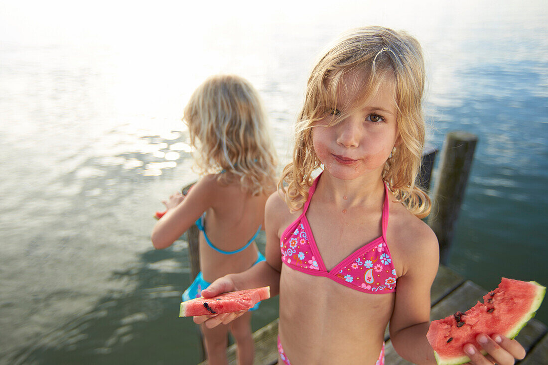 Zwei Mädchen essen Melone, Starnberger See, Oberbayern, Bayern, Deutschland