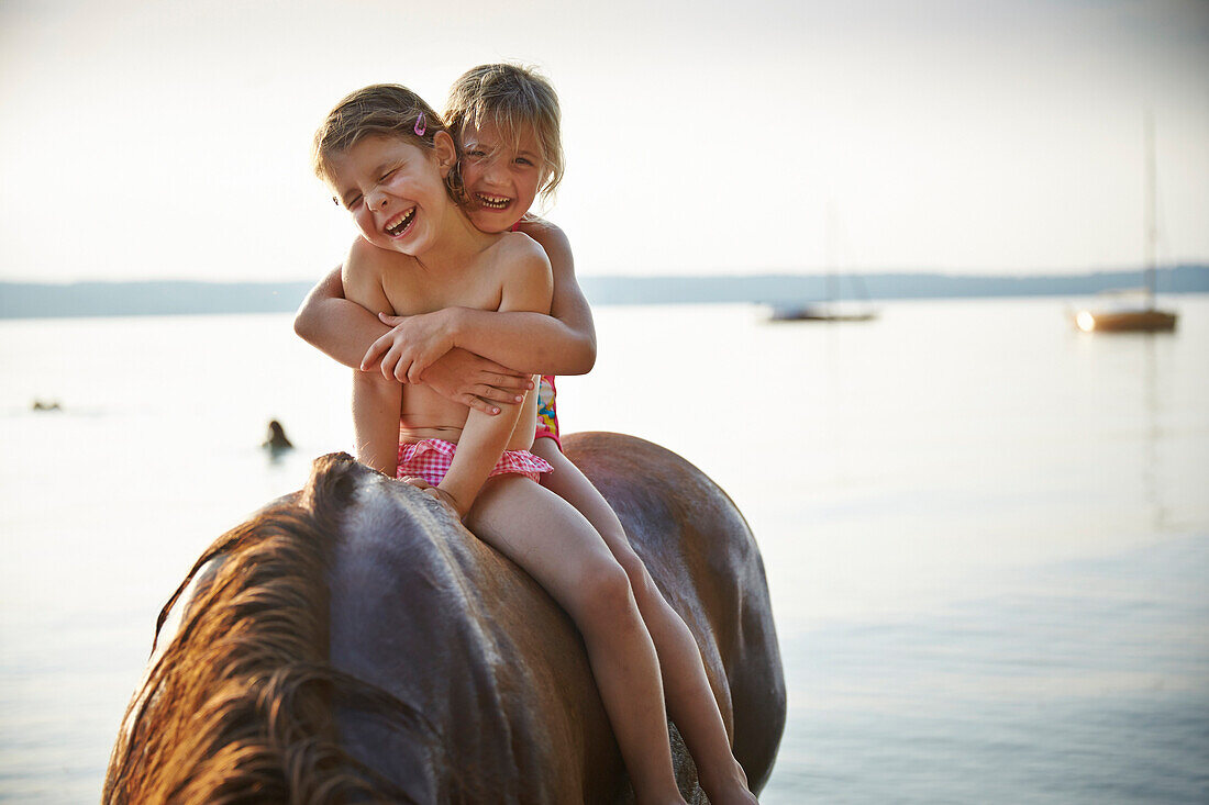 Two girls on horse back at lake Starnberg, Upper Bavaria, Bavaria, Germany