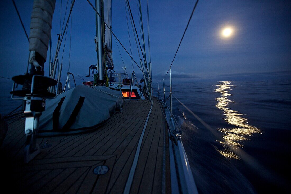 Sailing boat, yacht with night lighting system and full moon during Atlantic crossing, Sailing