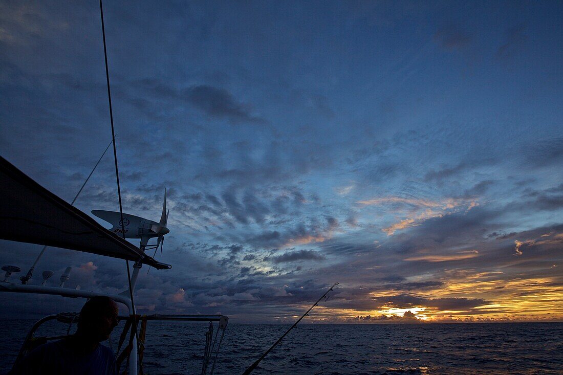 Wolkenstimmung bei Sonnenaufgang von einer Segelyacht mit Windgenerator auf dem Atlantik, Segeln