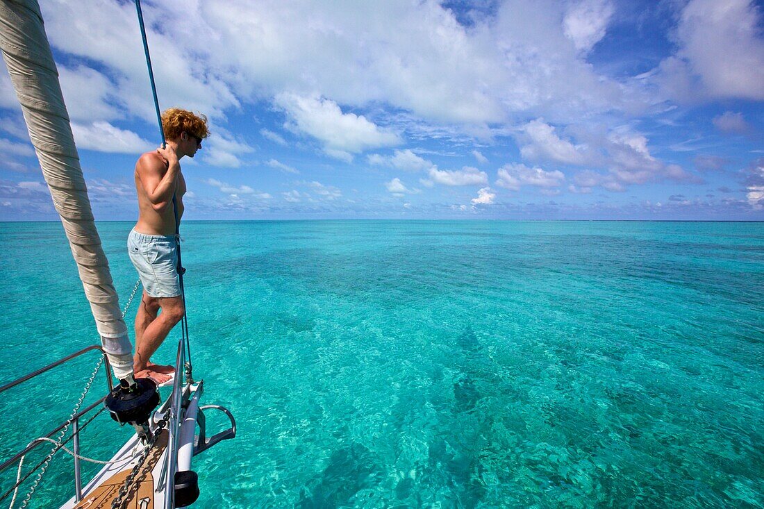 Yachtsman standing on the bow of a sailing boat, yacht in the Caribbean sea