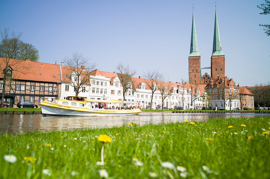 View over river Trave with excursion boat to historic city with Lubeck Cathedral, Lubeck, Schleswig-Holstein, Germany