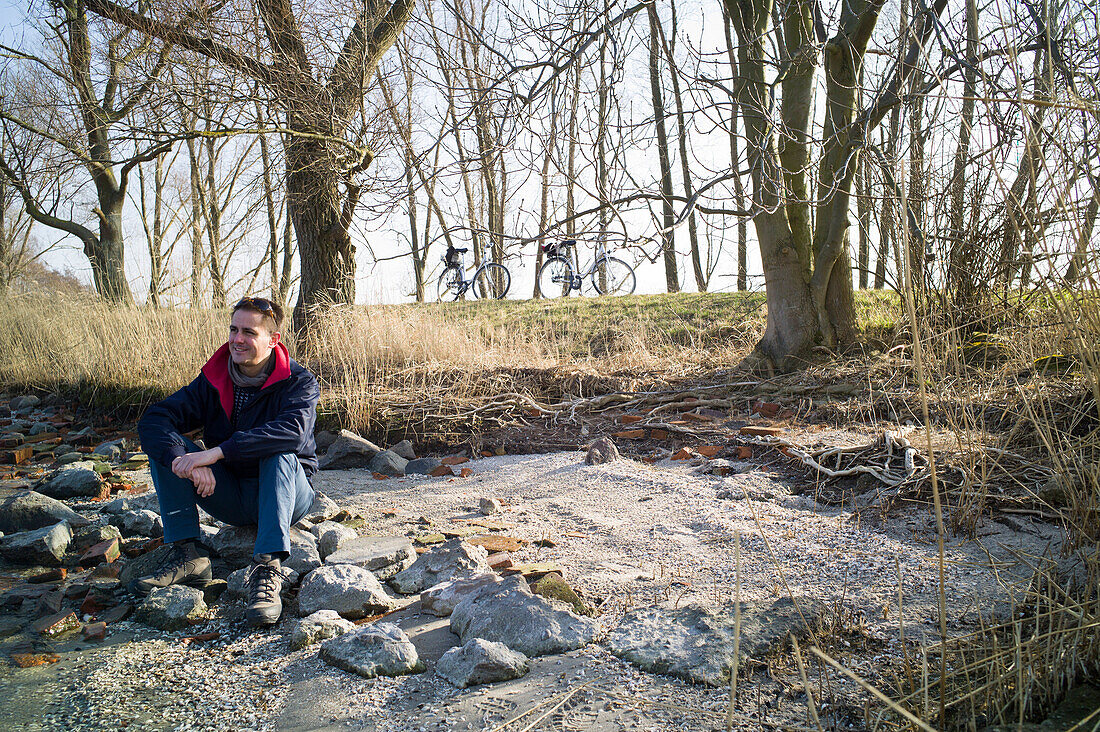 Mann sitzt am Strand, Rankwitz, Halbinsel Lieper Winkel, Usedom, Mecklenburg-Vorpommern, Deutschland