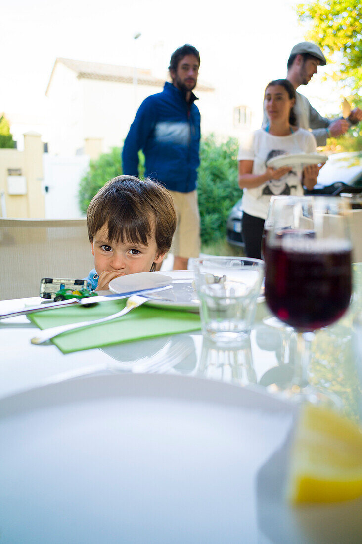 Junge sitzt an einem Tisch, Perols, Montpellier, Herault, Languedoc-Roussillon, Frankreich