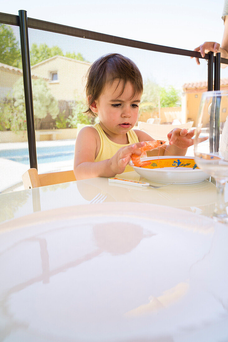 Girl eating king prawn, Perols, Montpellier, Herault, Languedoc-Roussillon, France