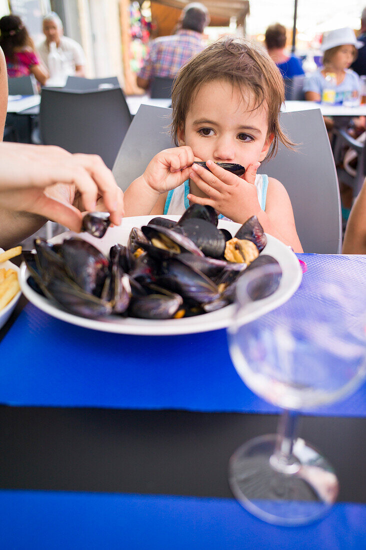 Mädchen isst Miesmuscheln, Palavas-les-Flots, Montpellier, Herault, Languedoc-Roussillon, Frankreich