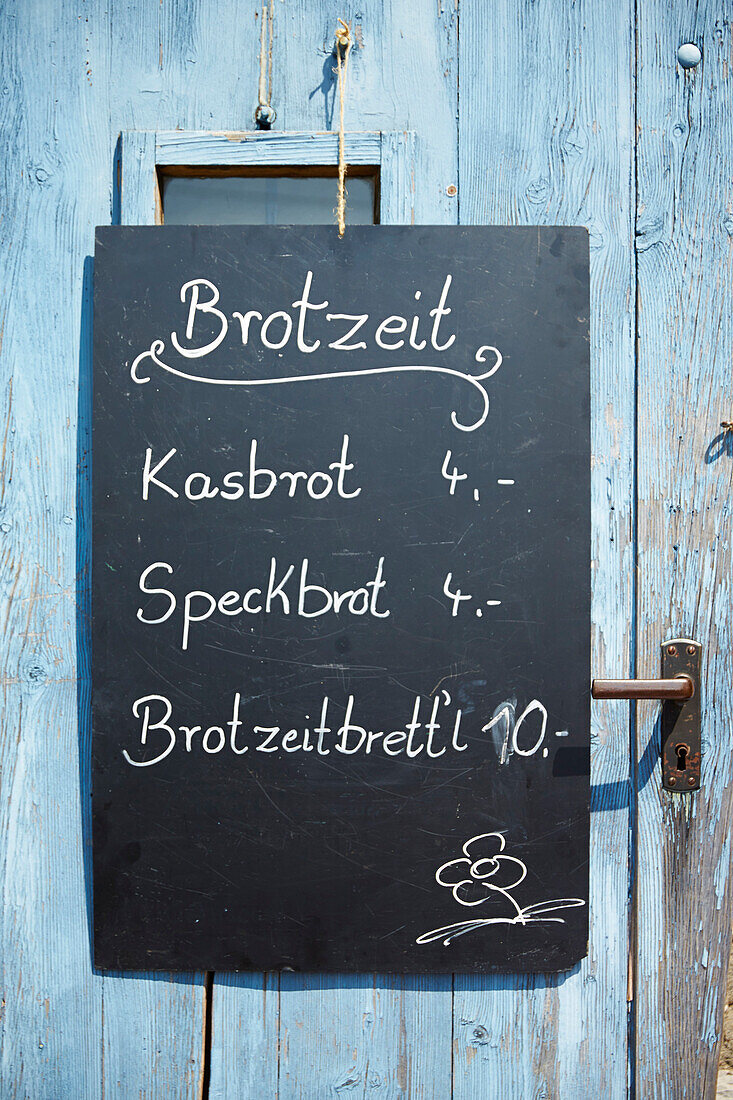 Blackboard at a wooden door, Wendelstein, Upper Bavaria, Germany