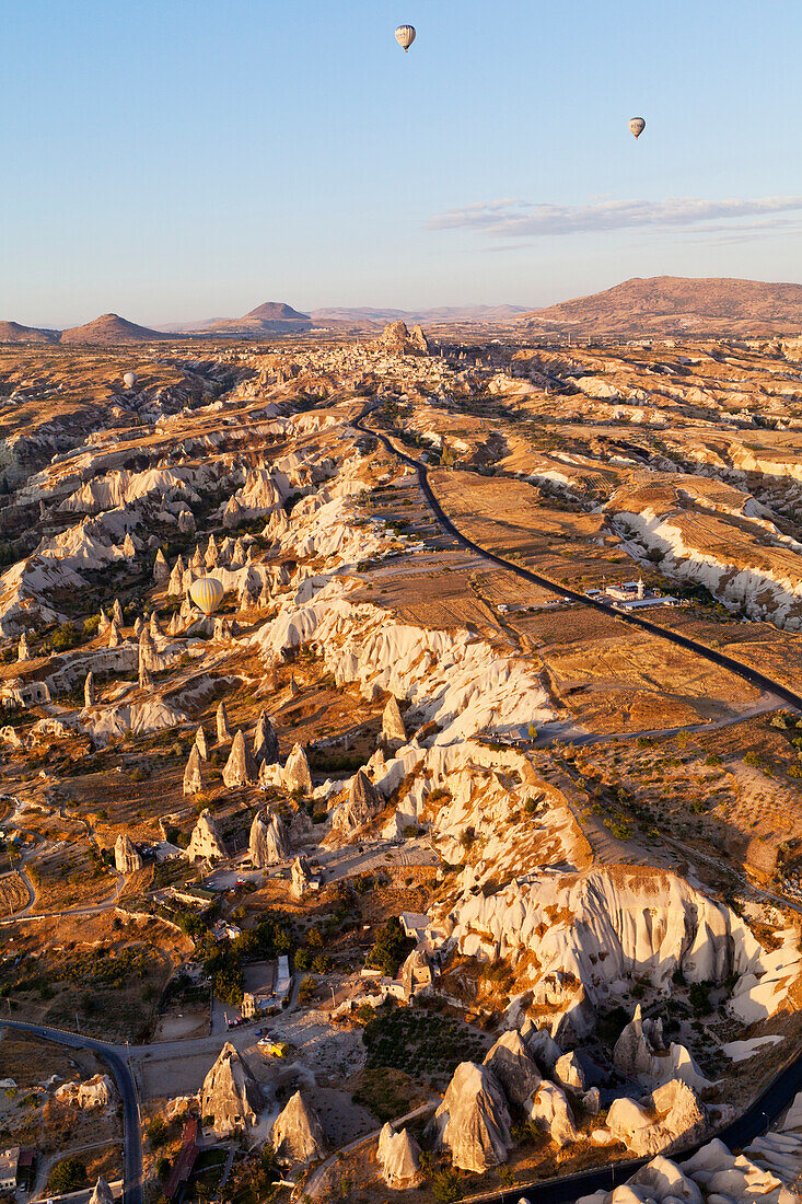 'Hot air balloons in flight over a rugged landscape; Cappadocia, Turkey'