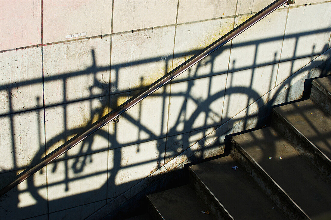 'Shadow of a railing and bicycle cast on a wall along steps; Paris, France'