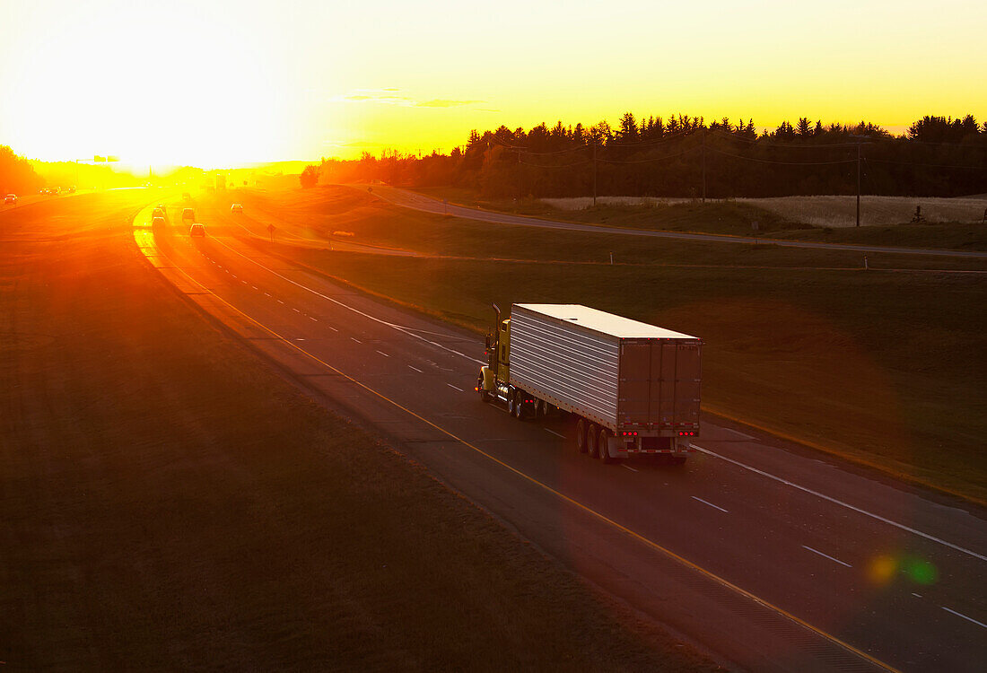 'Truck heading down a highway at sunset; Edmonton, Alberta, Canada'