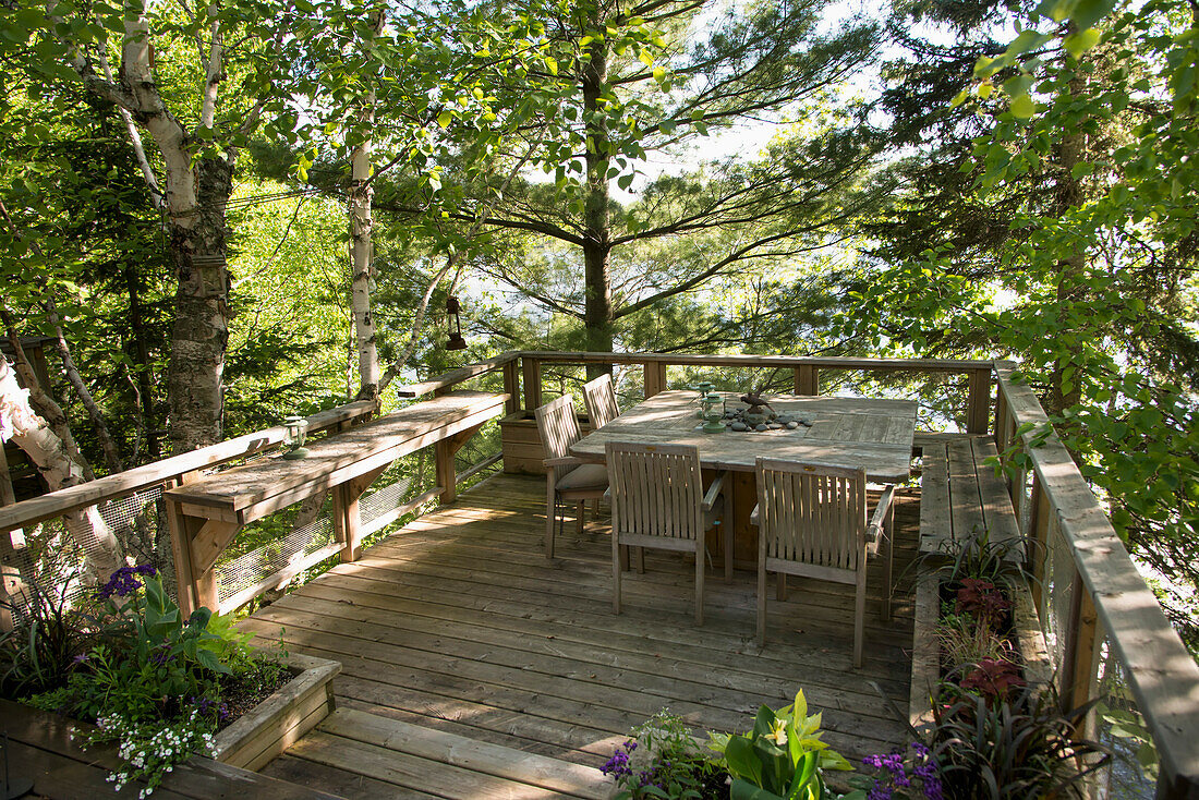 'A wooden deck with seating and a view of the lake; Ontario, Canada'