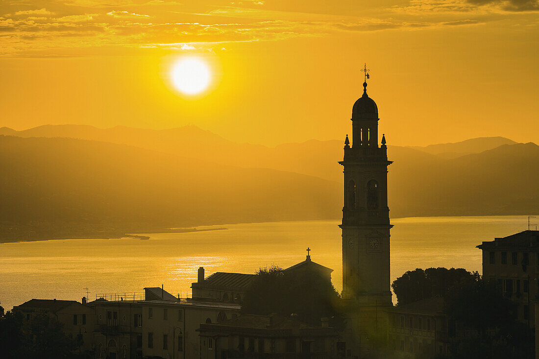 'Golden sky at dusk with tower of church; San Lorenzo della Costa, Liguria, Italy'