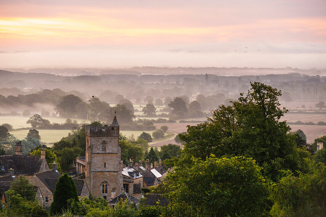 St. Lawrence Church and misty sunrise, Bourton-on-the-Hill, Gloucestershire, The Cotswolds, England, United Kingdom, Europe