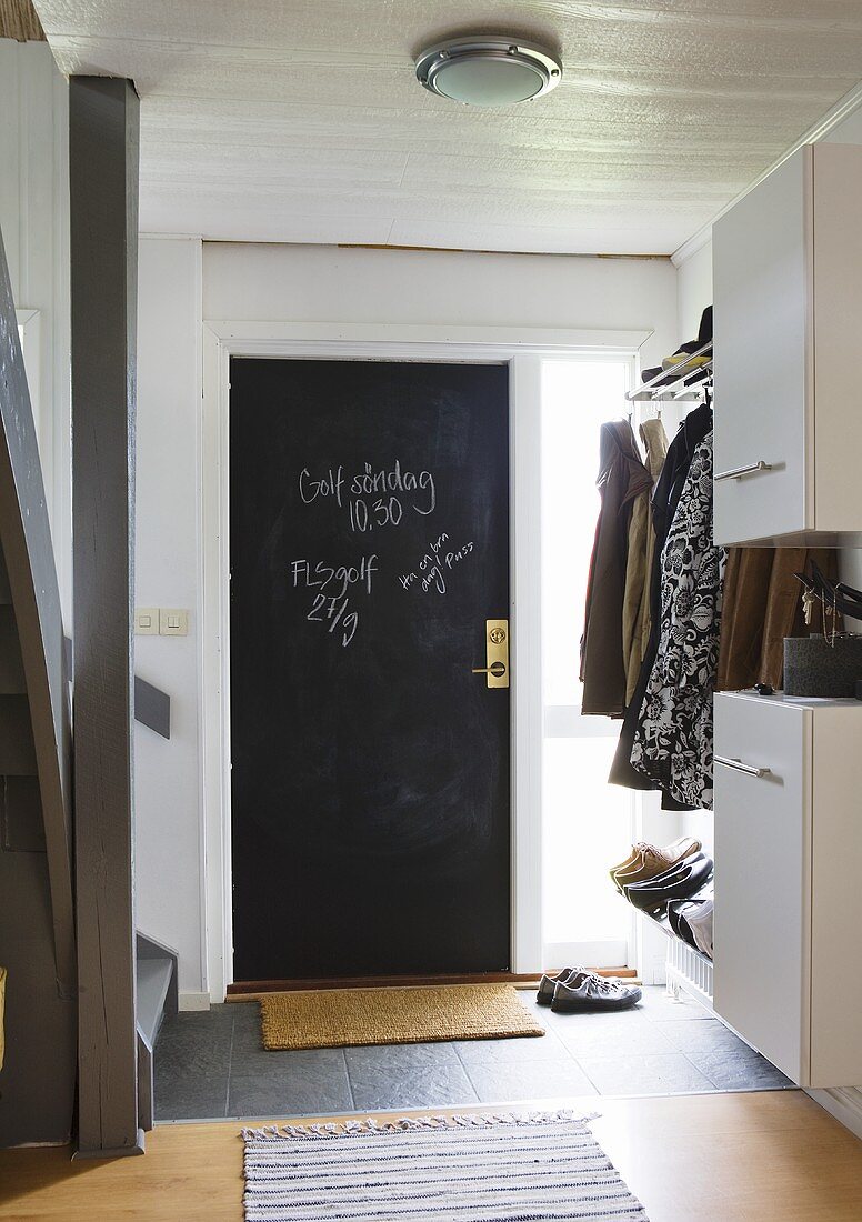 Schwarze Zimmertür und Garderobe im Treppenhaus