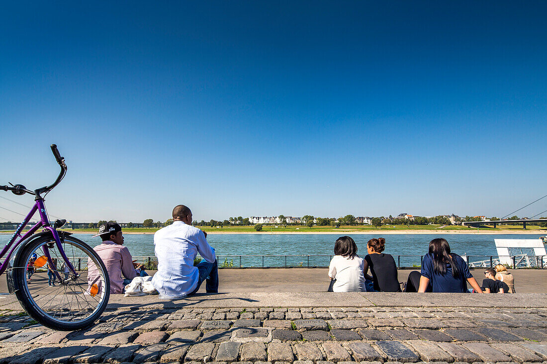 People sitting along the Rhine promenade, Duesseldorf, North Rhine Westphalia, Germany