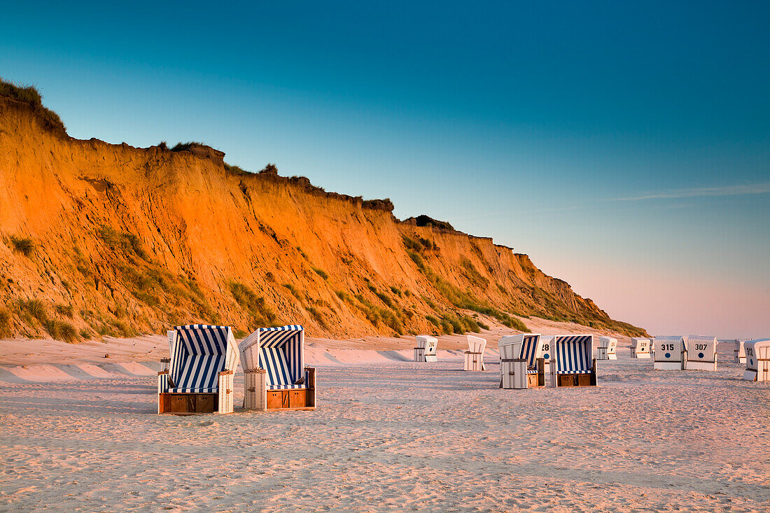 Beach chairs on the beach at sunset, red cliff, Kampen, Sylt Island, North Frisian Islands, Schleswig-Holstein, Germany