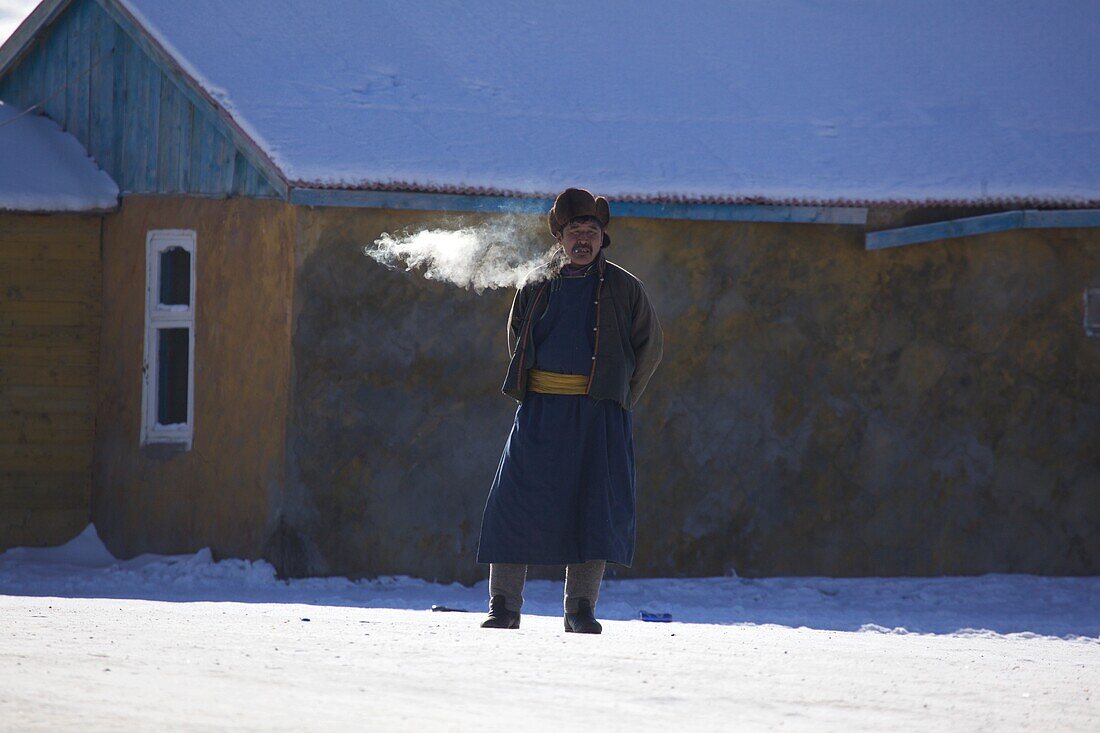 Mongolian man smoking in the traditional Deel, Mongolia