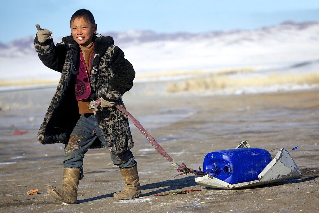 Mongolian boy with toy sledge, Mongolia