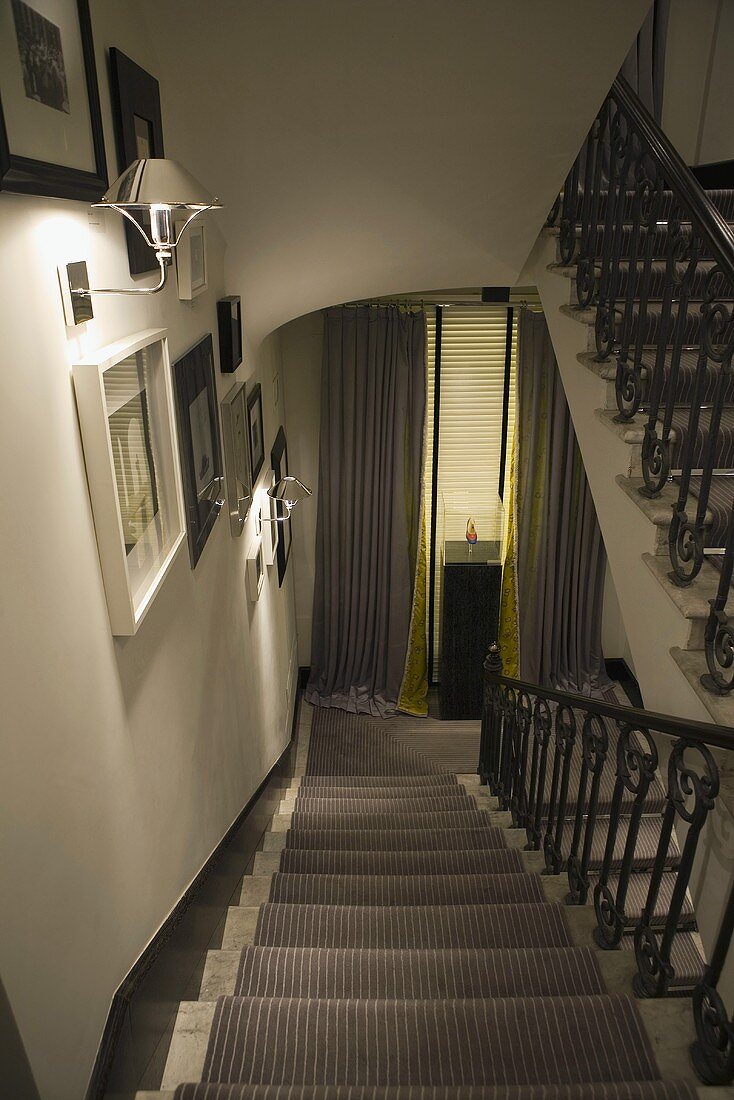 Stairway with ambient wall lighting with a stair runner and metal handrail