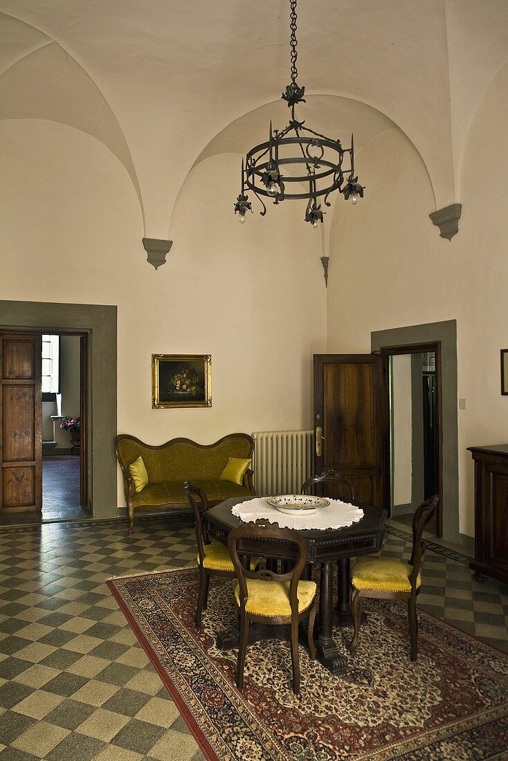 Deckengewölbe im Salon einer Villa mit antikem Mobiliar auf Schachbrettmusterboden und Blick auf offenstehende Tür