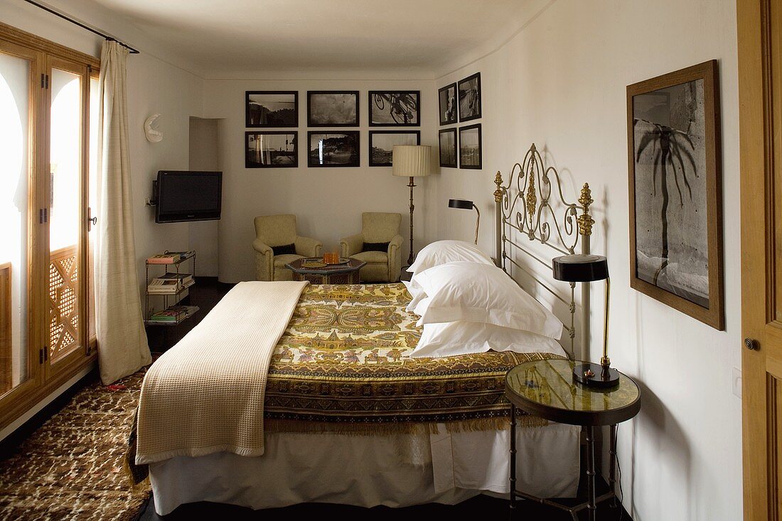 Bedroom with a double bed and seating corner with a collection of pictures