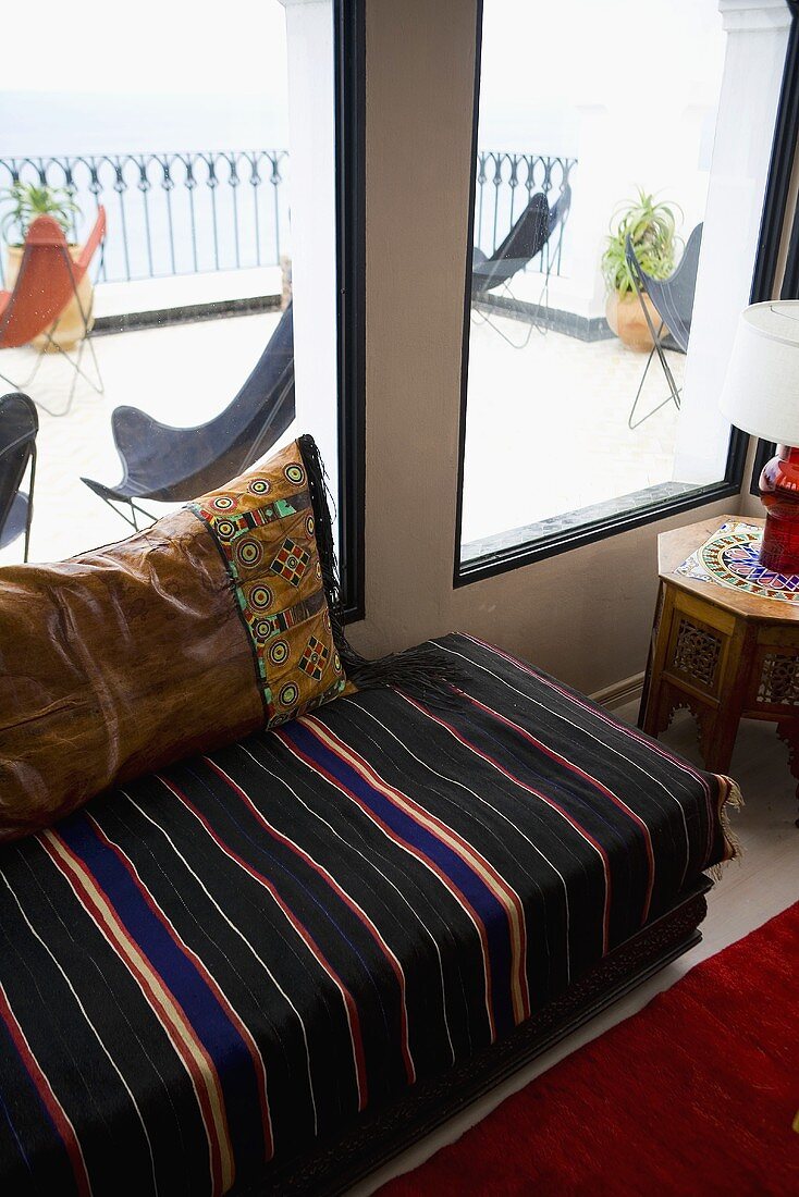 Upholstered seating in front of a window with a view onto the terrace