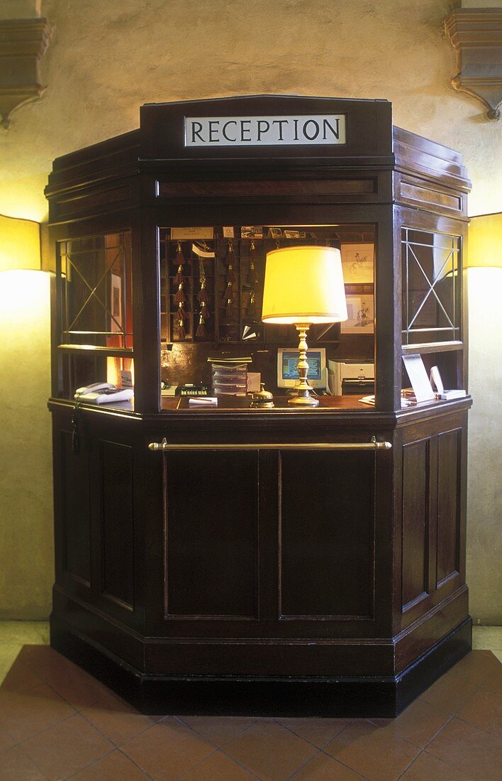 Antique hotel reception desk with a table lamp