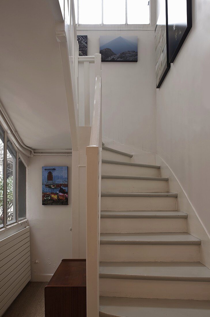 Looking up a country style stairway with white treads and railing