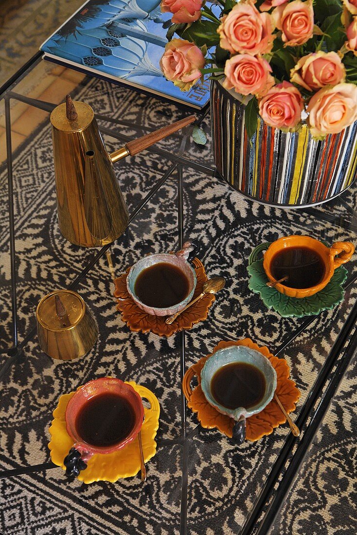 'Coffee break oriental style' -- colorful coffee cups with coffee on a glass table