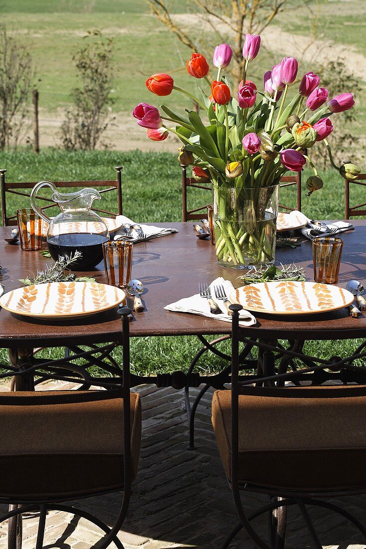 A bunch of colourful tulips on a table laid in the open air