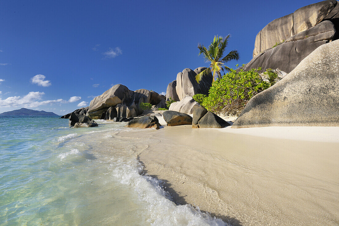 Famous beach Anse Source d'Argent with palm trees and sculpted rocks, La Digue Island, Seychelles, Indian Ocean.