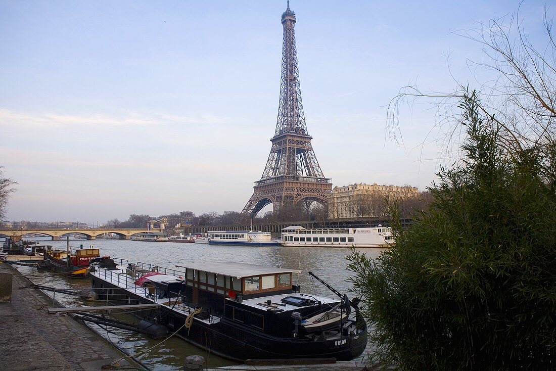 Sunny day in Paris - house boat docked on the bank looking across the Seine at the Eiffel tower
