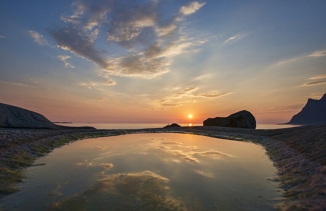 the midnight sun over the Arctic from Uttakleiv Beach in the Lofoten Islands, Norway.