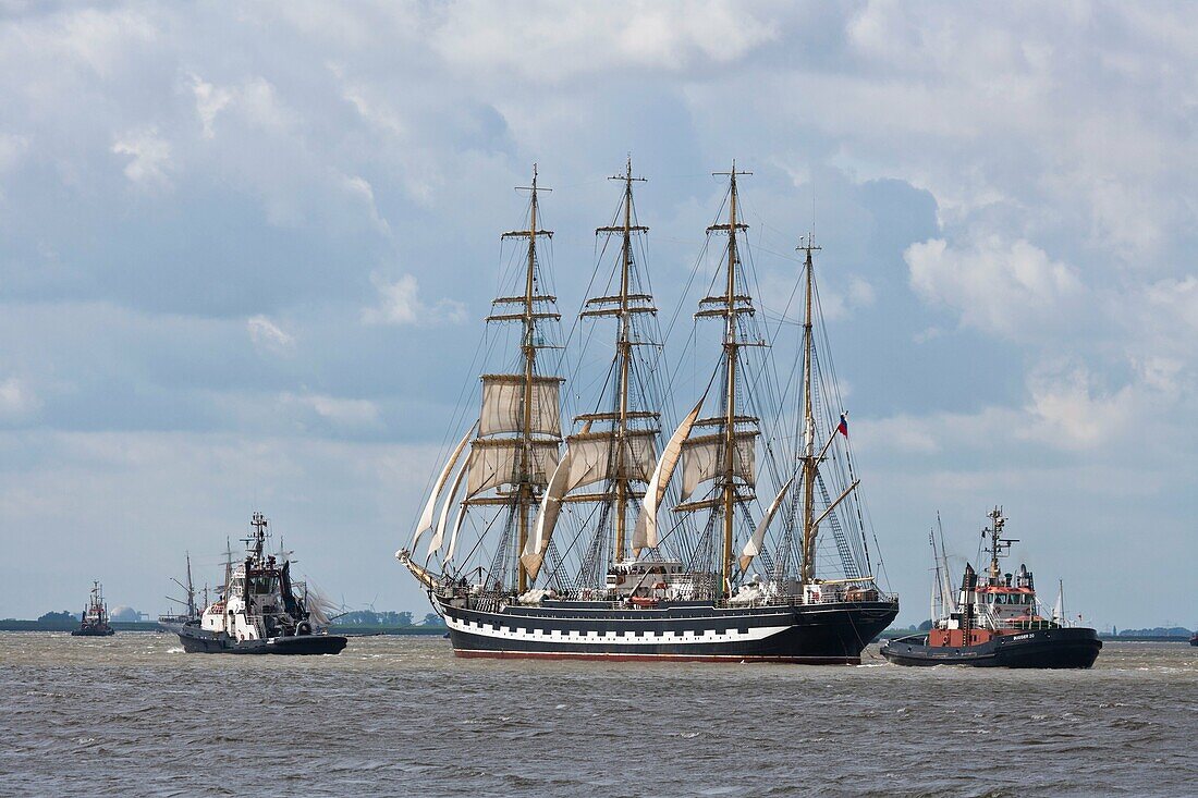 Russian tall ship Kruzenstern and two towboats on the river Weser in Bremerhaven, Germany, Europe