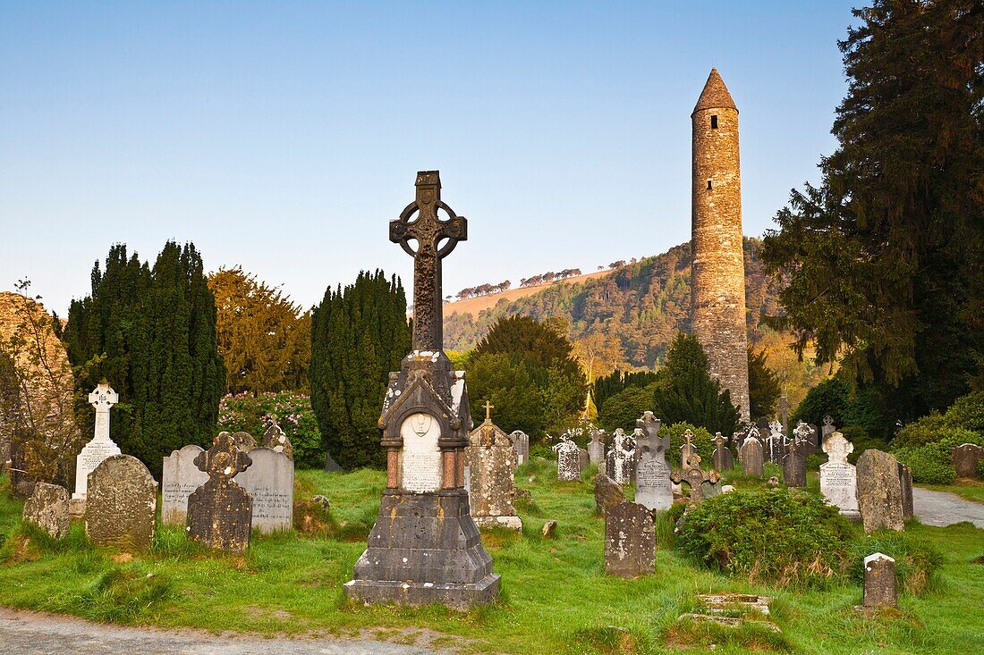 Round tower and gravestones at the historic site of Glendalough, County Wicklow, Ireland, Europe