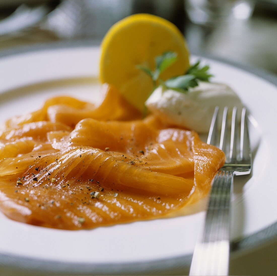 Slices of salmon on a plate with a fork