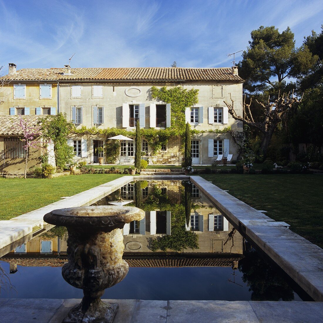 Haus in der Provence und antik griechisches Gefäss am Pool im Garten
